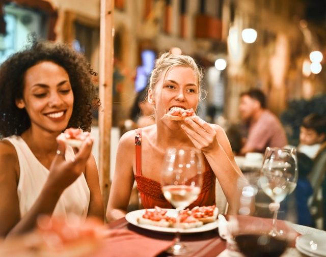 two women casual dining with a glass of wine