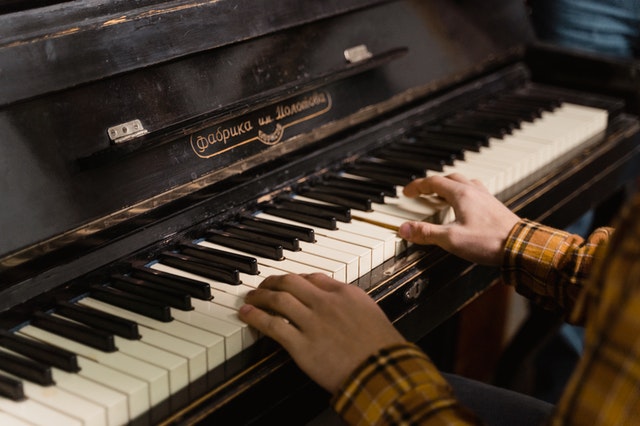 A gentleman's hands on the keys of a black piano