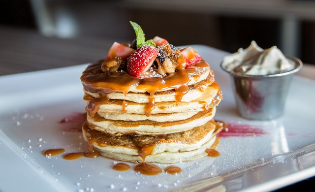 stack of pancakes topped with strawberries
