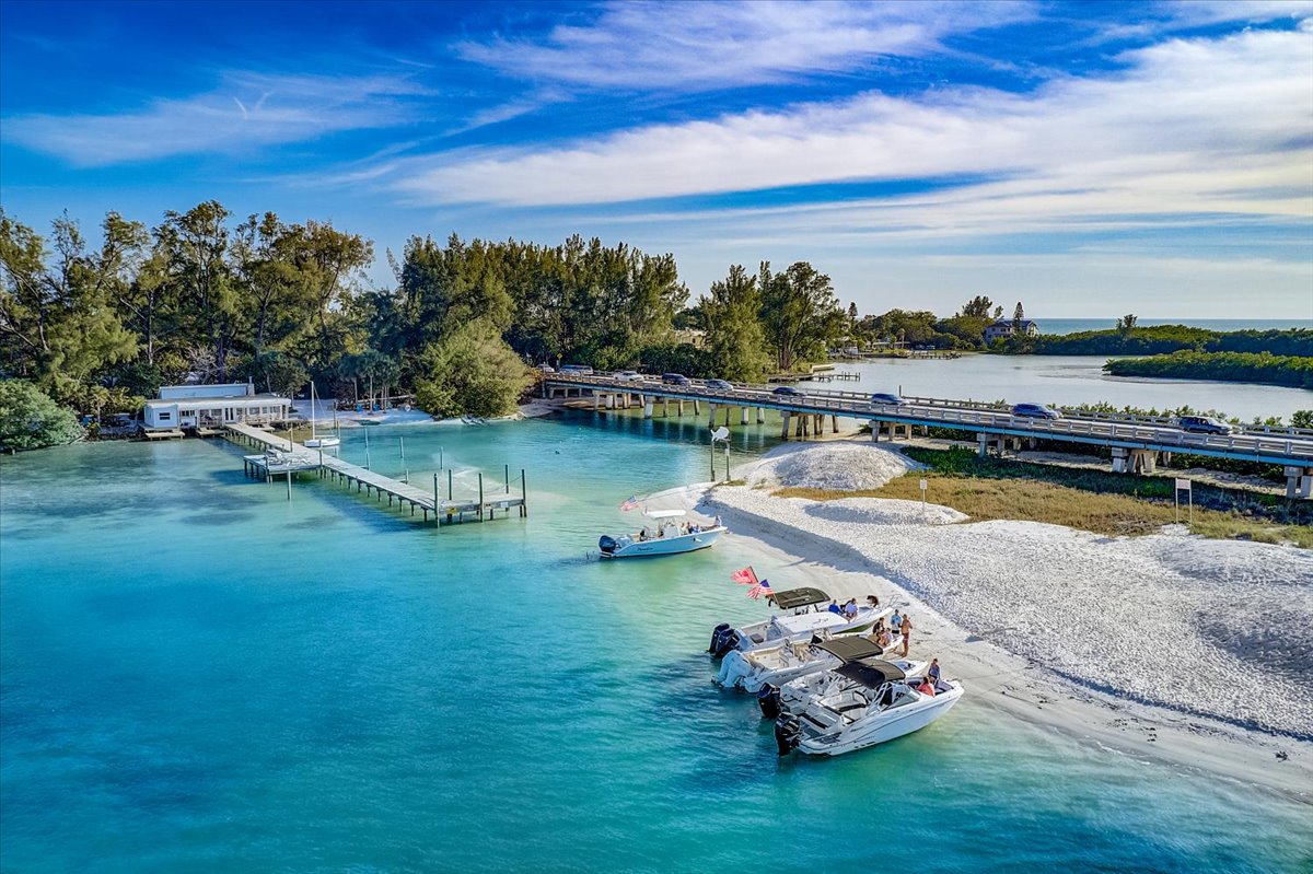 an aerial view of north longboat key capturing the green blue waters, soft white sand and boats as one of the many things to do in Longboat Key, Florida.