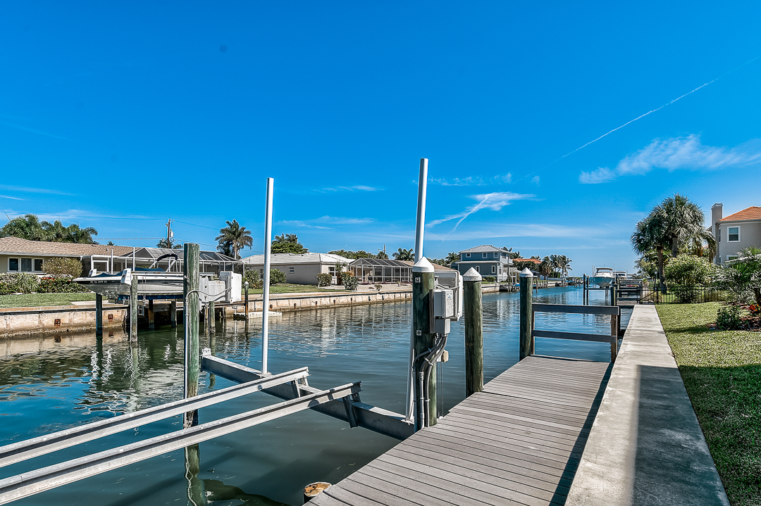 A photo of a dock and boat lift along the canal at Country Club Shores in Longboat Key, Florida.