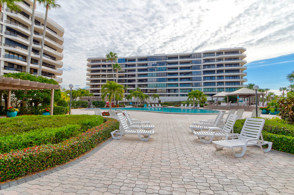 The Sanctuary community pool featuring a paver brick pool area and white lounge chairs around the pool